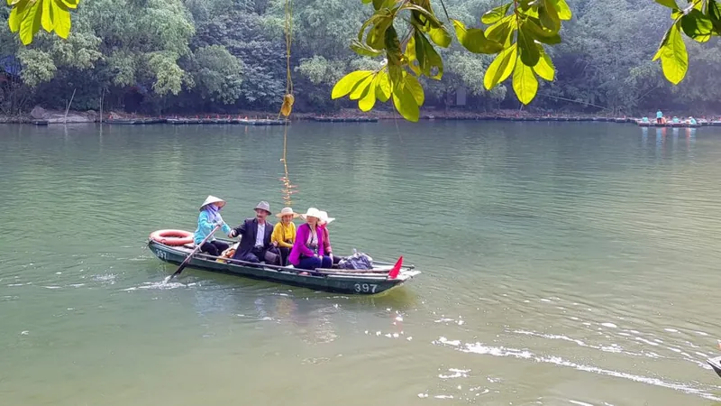Reizigers in een roeibootje op de rivier in Ninh Binh