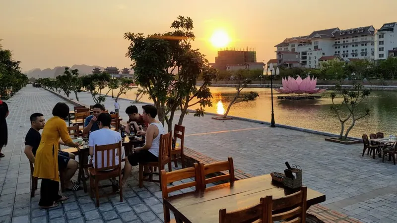 Terras aan het water bij zonsondergang, met kalksteenbergen op de achtergrond